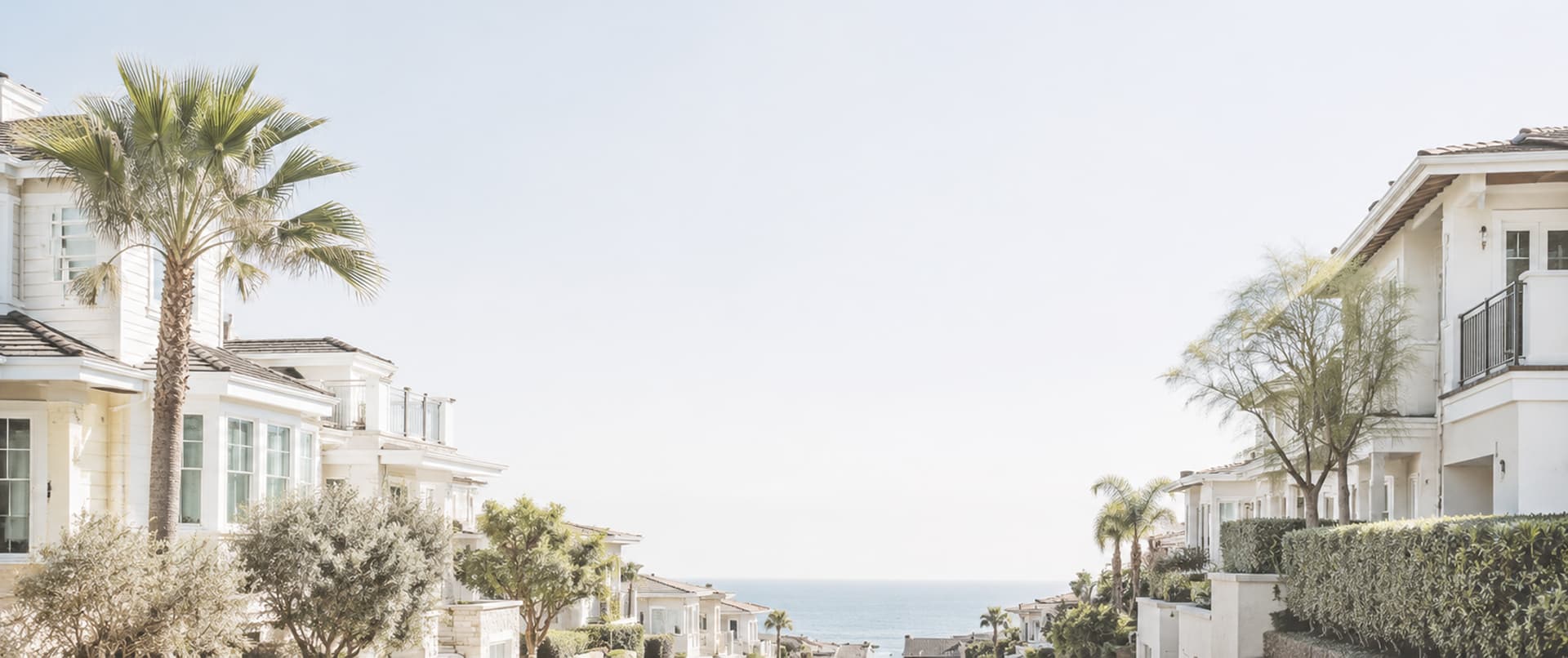 Sunlit coastal residences opening toward an ocean view