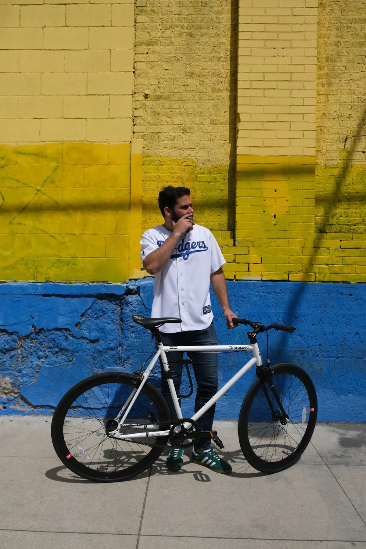 A cyclist pausing beside a colorful wall in Culver City