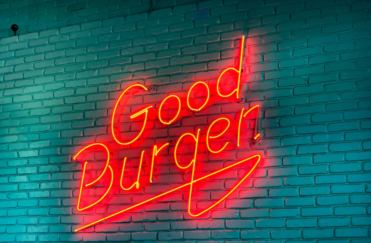 A Good Burger neon sign glowing on a brick wall in Culver City