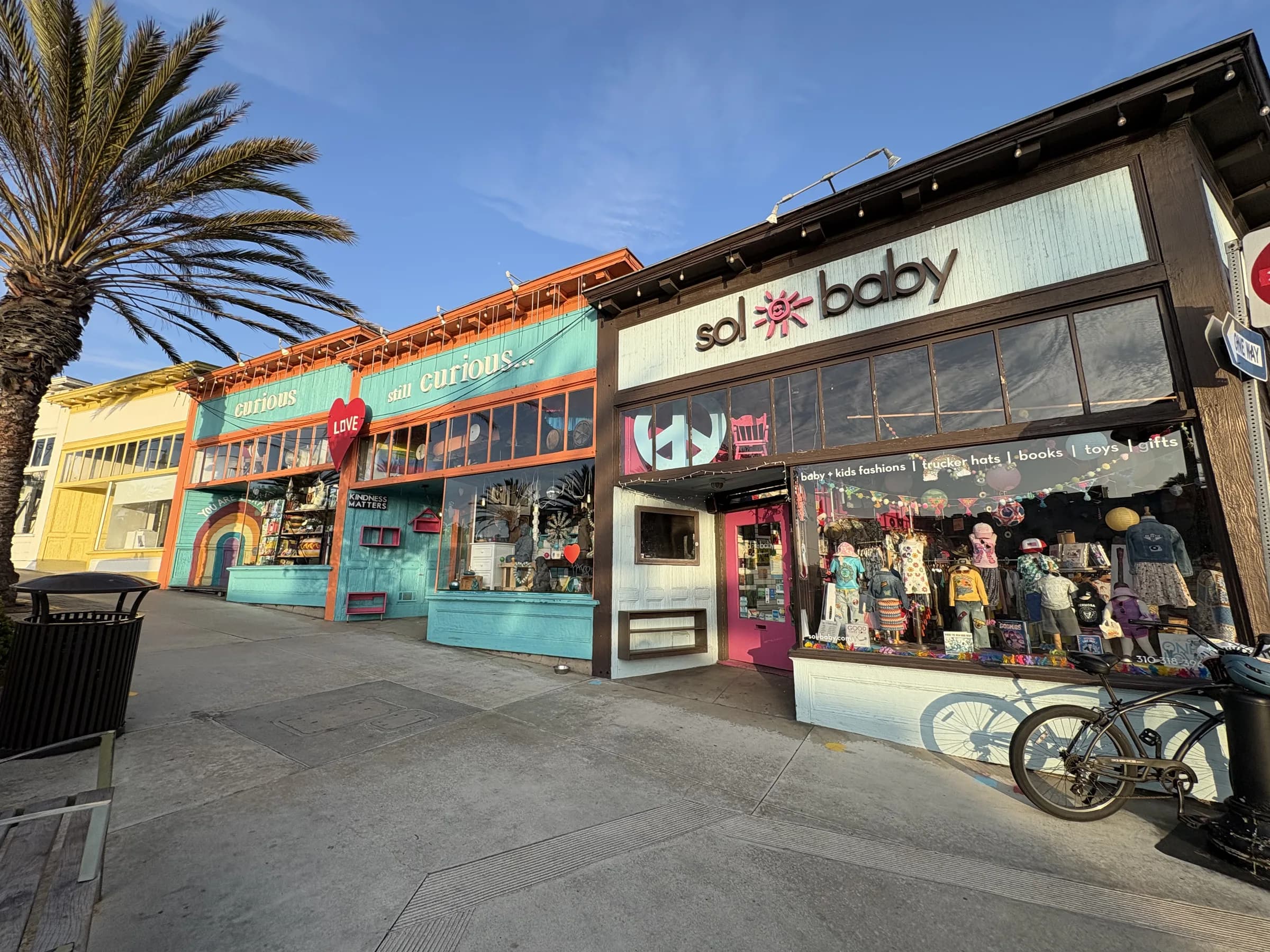 A colorful independent storefront beneath palms in Hermosa Beach