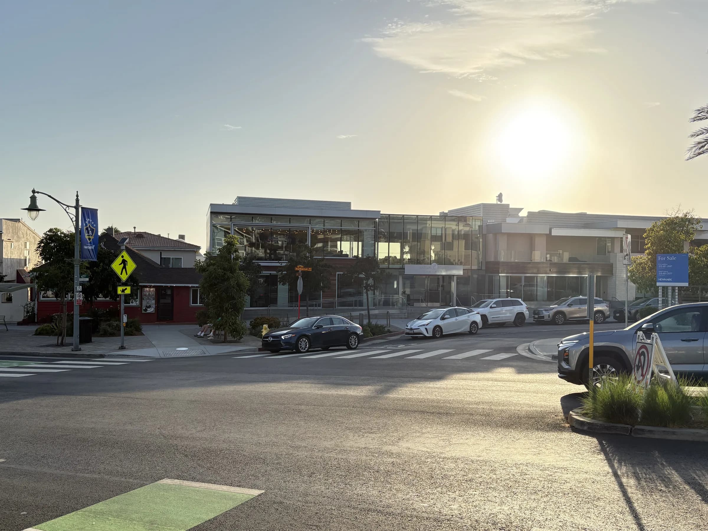 Local businesses and an active crosswalk in warm evening light