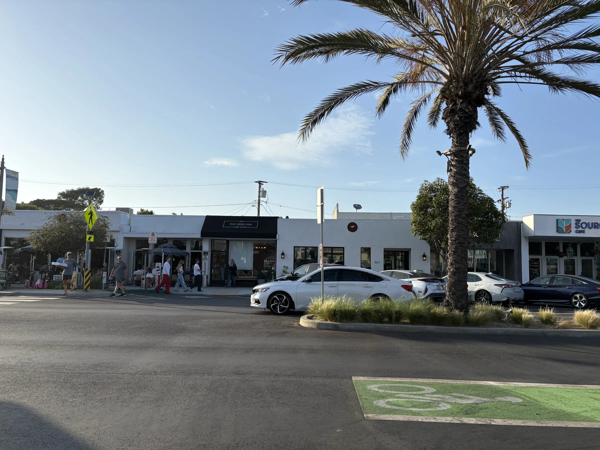 A palm-anchored row of neighborhood businesses in Hermosa Beach
