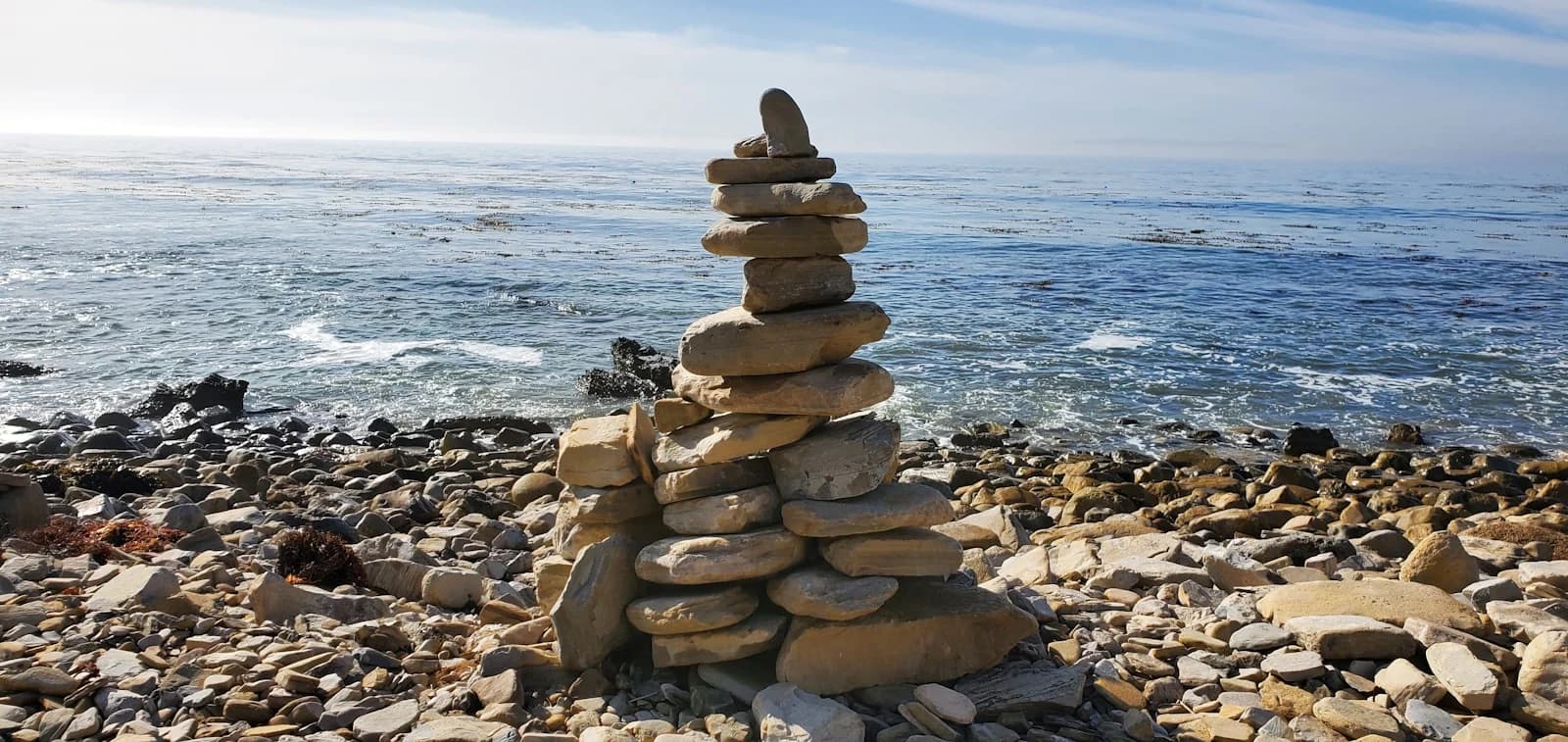 A balanced stack of beach stones beside the Pacific