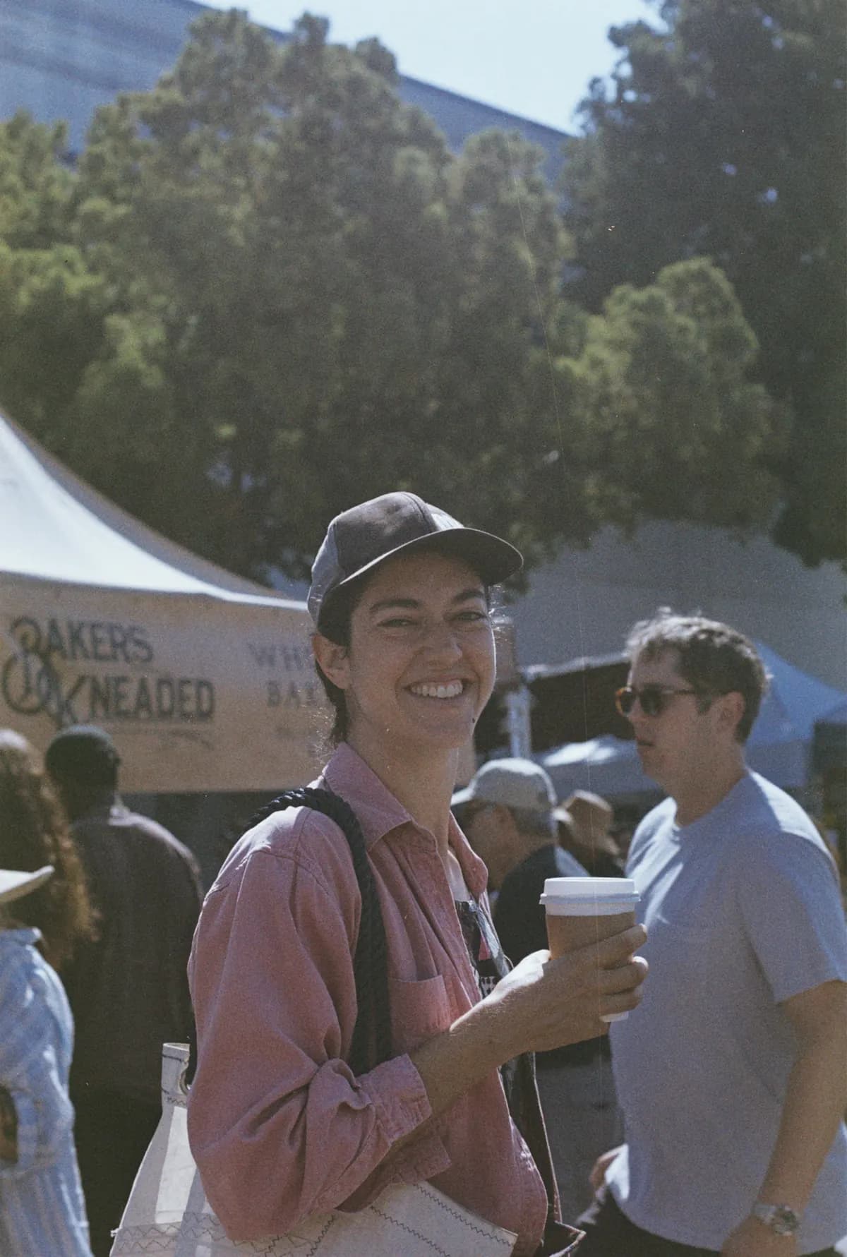A visitor enjoying coffee at a neighborhood farmers market