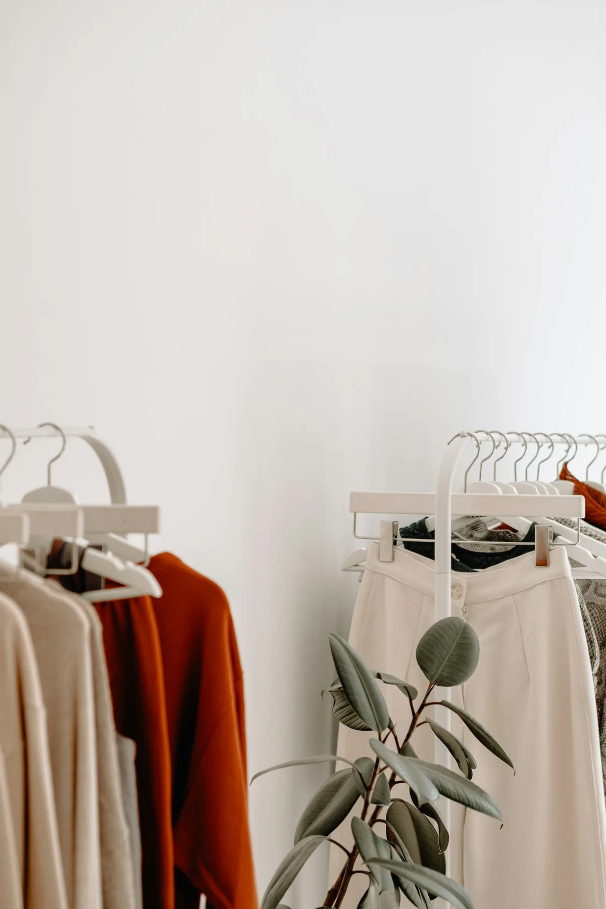 Neutral-toned clothing arranged inside a bright boutique