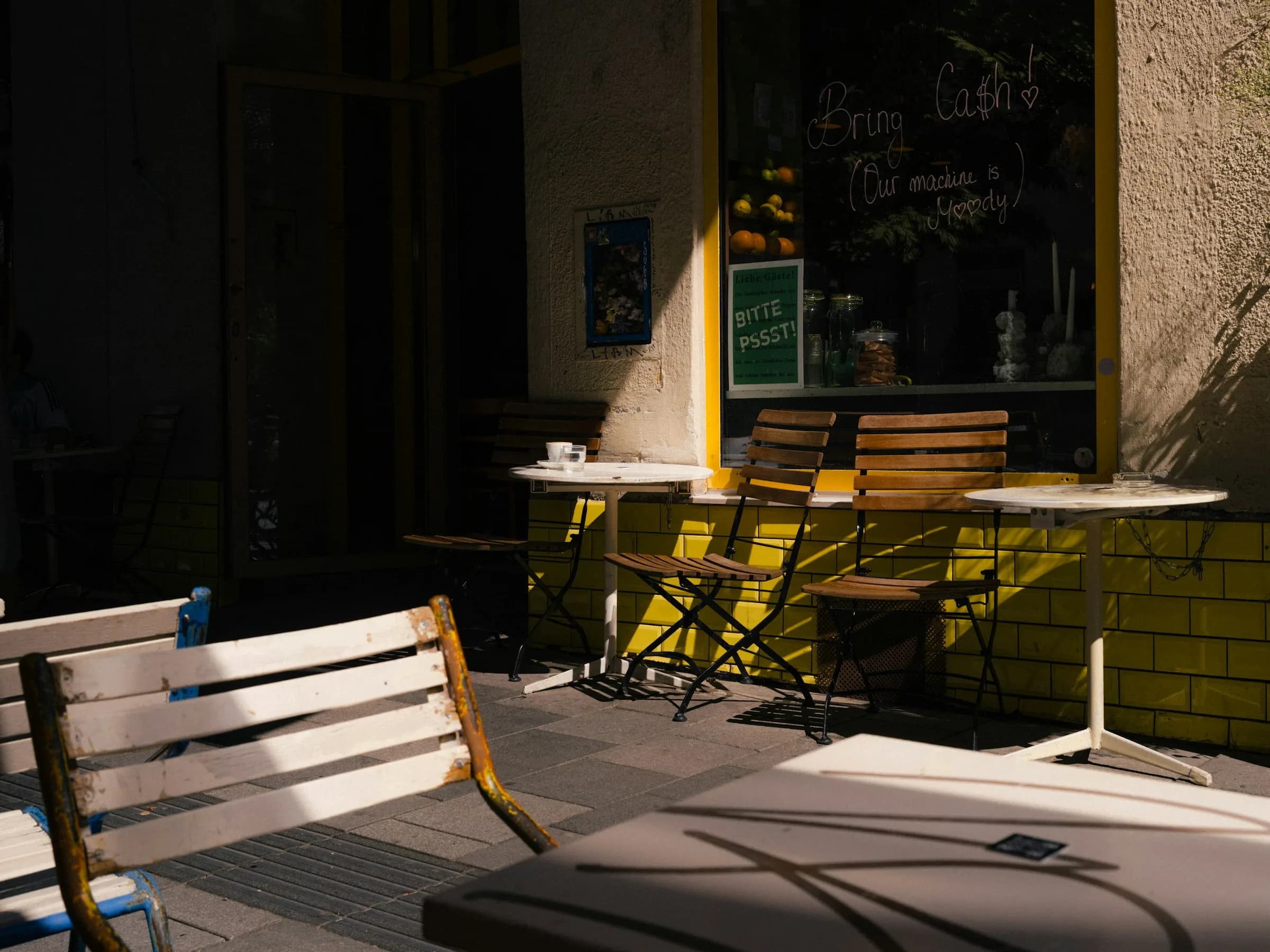 Quiet outdoor cafe tables warmed by afternoon light