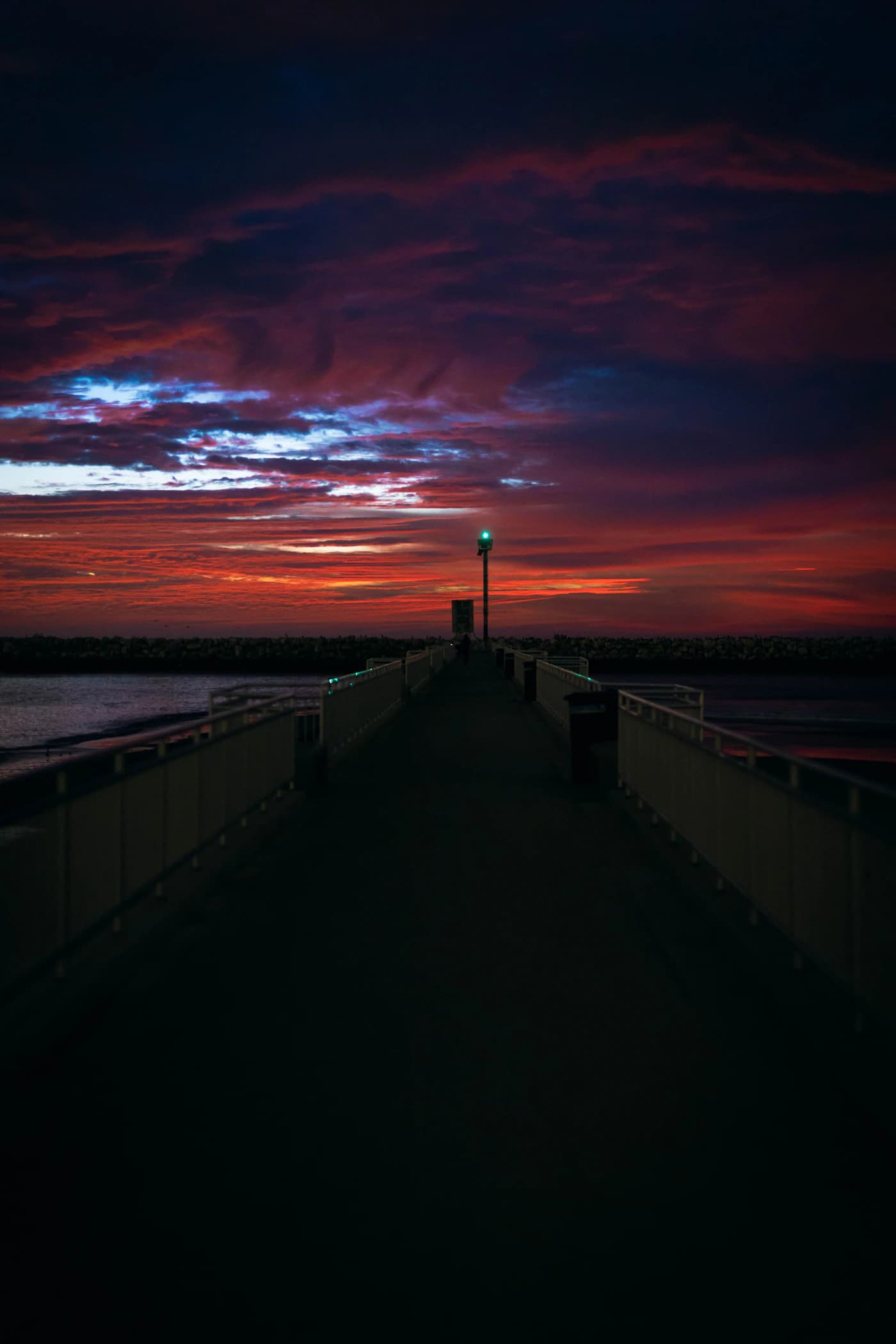 A quiet dock at Marina Beach framed by a vivid sunset