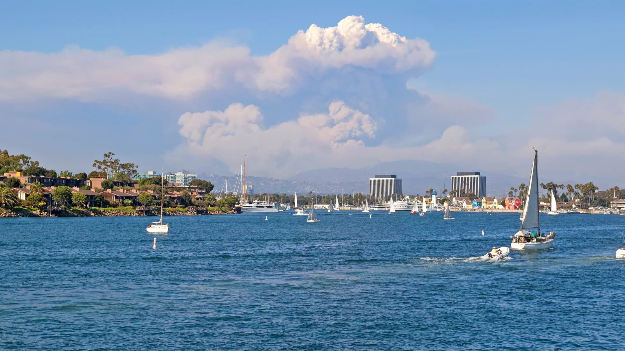Boats crossing the broad Marina del Rey channel beneath a blue sky