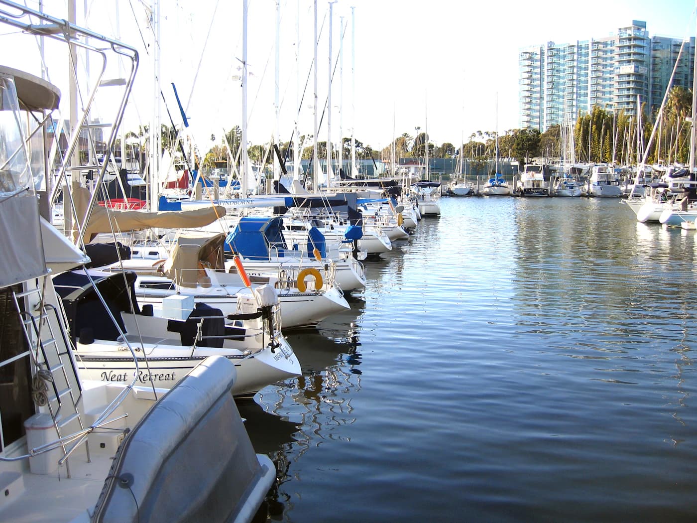 Boats moored along a calm residential dock in Marina del Rey
