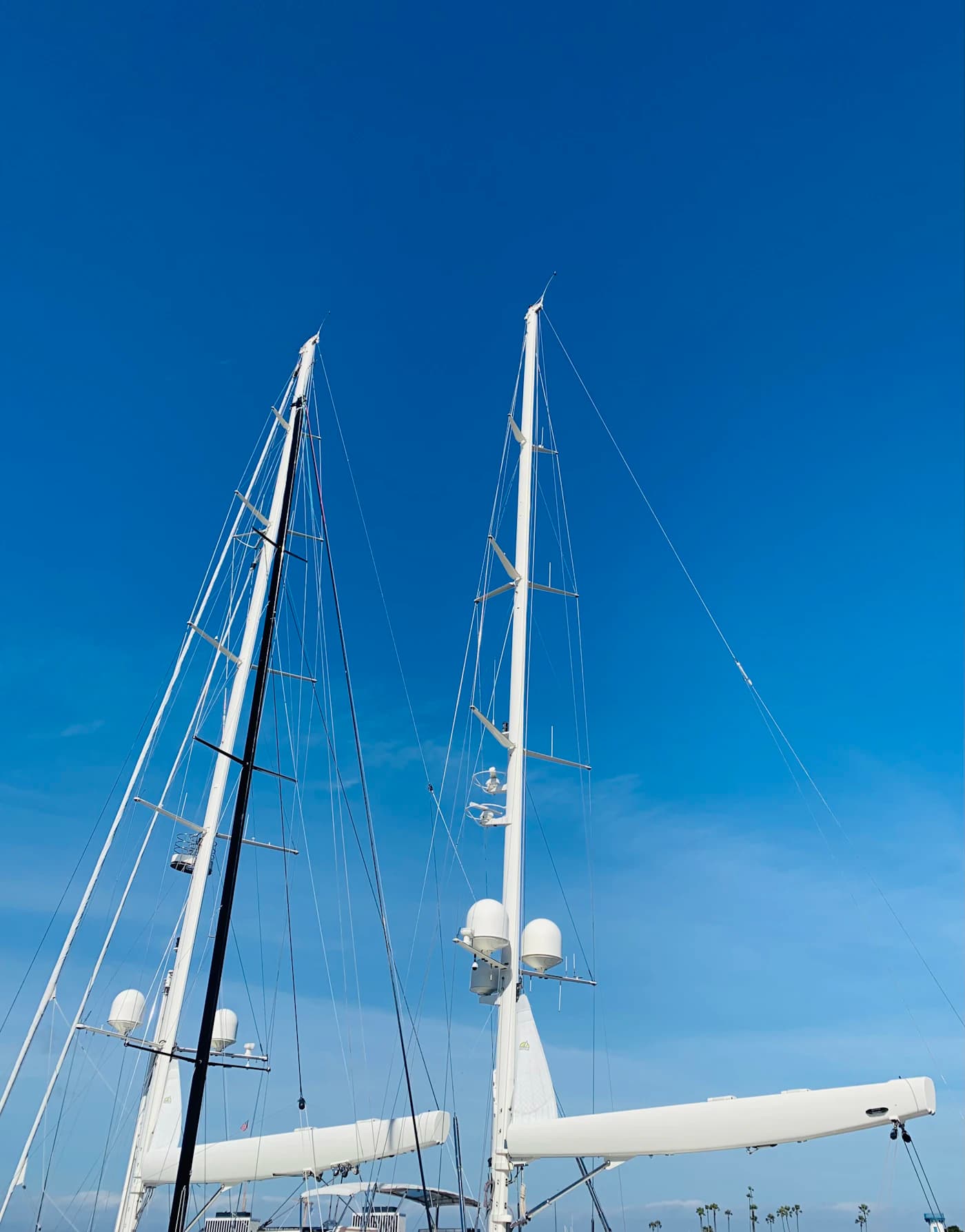 A white sailboat rising against the clear blue Marina del Rey sky