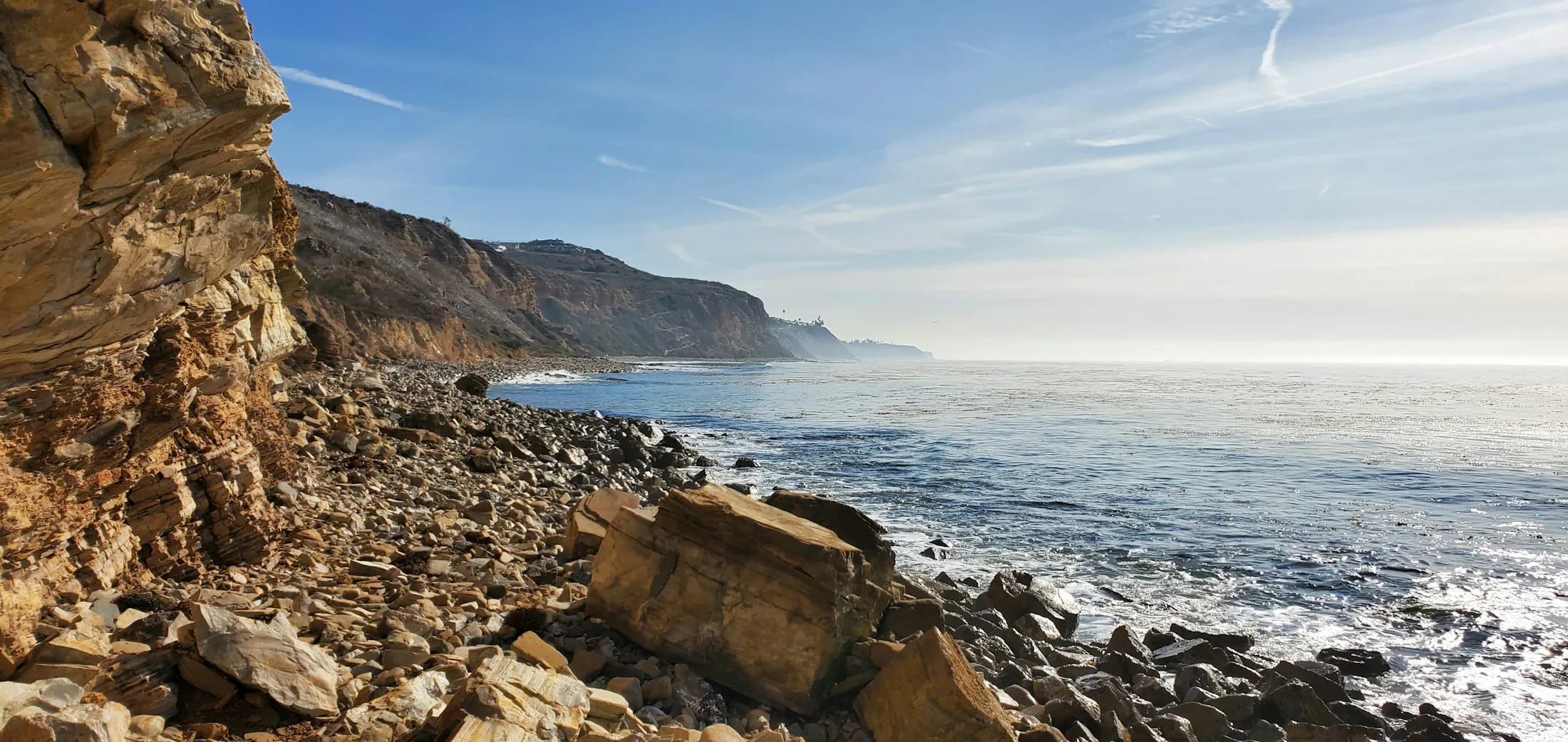 A rocky Palos Verdes shoreline beneath the peninsula bluffs