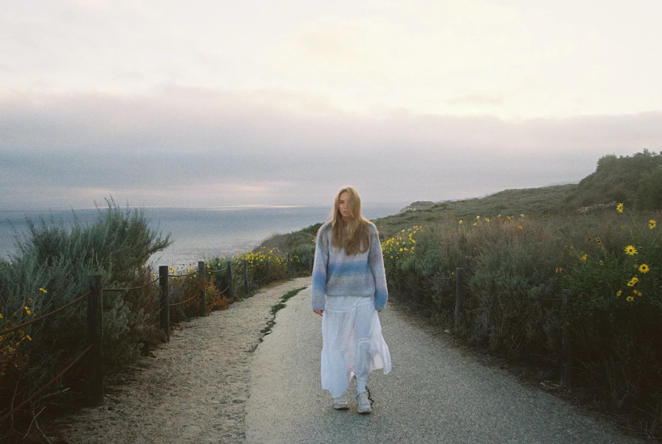 A walker following a wildflower-lined Palos Verdes coastal path