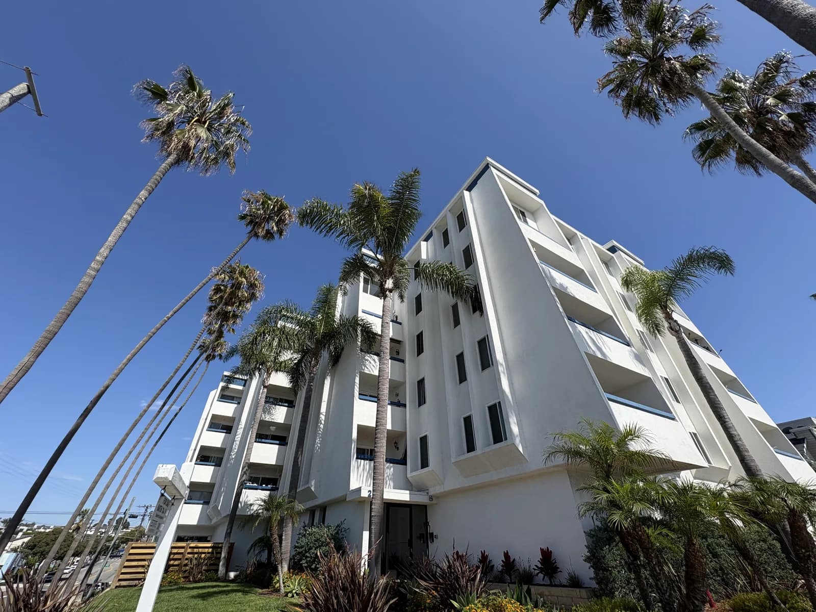Coastal apartment tower and palms along a Redondo Beach avenue