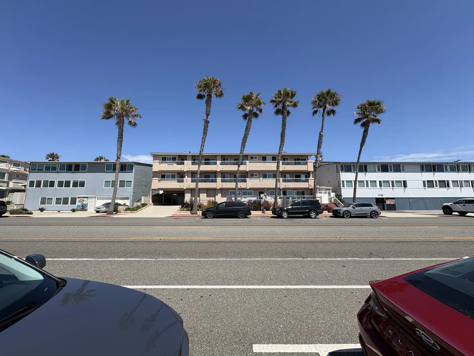 Palm-lined apartment building near local shops and the coast