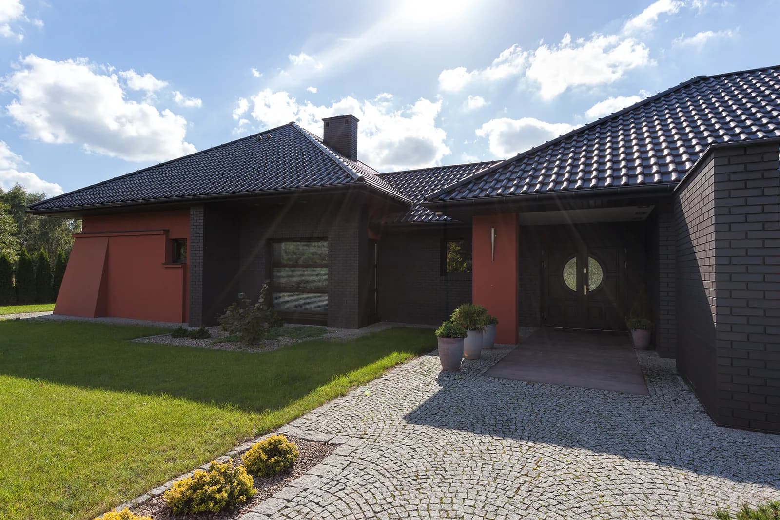 A low-profile residence with a broad paved entry court