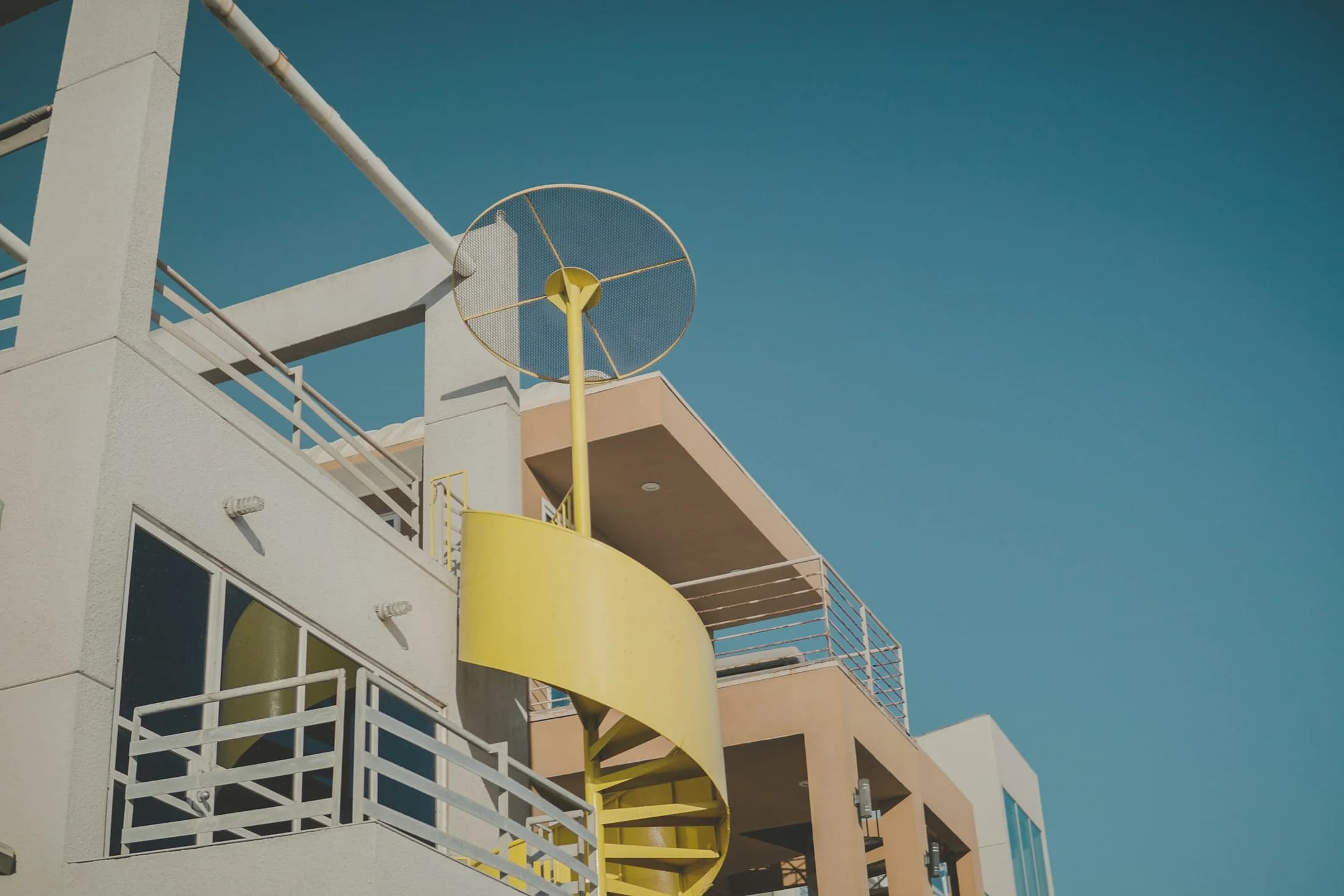 A colorful spiral staircase on a modern Santa Monica building