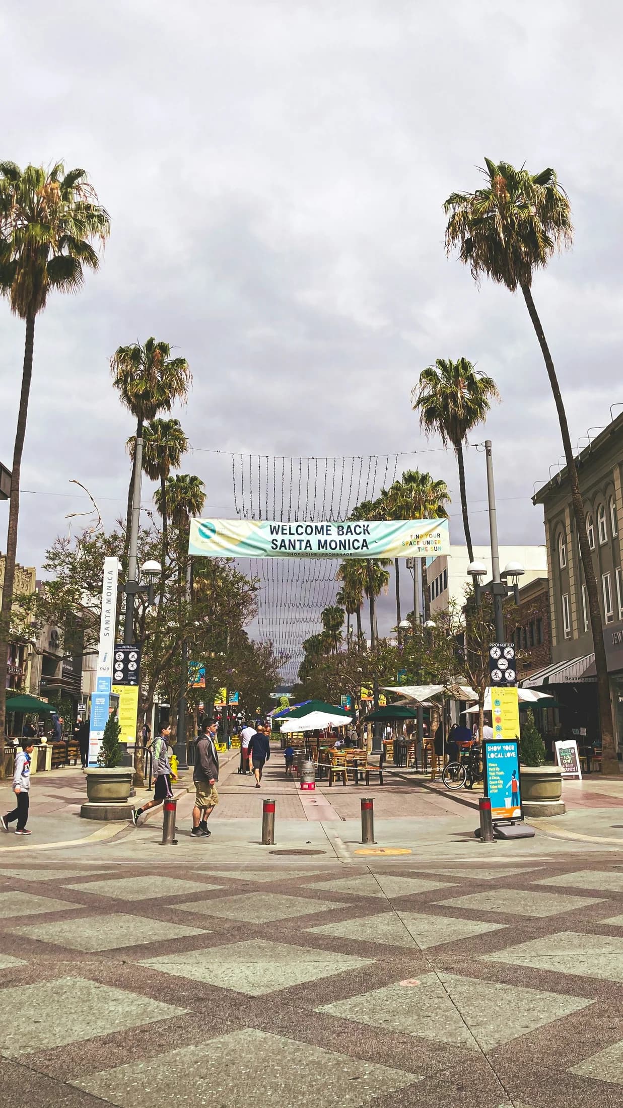 Pedestrians at a palm-lined intersection in downtown Santa Monica