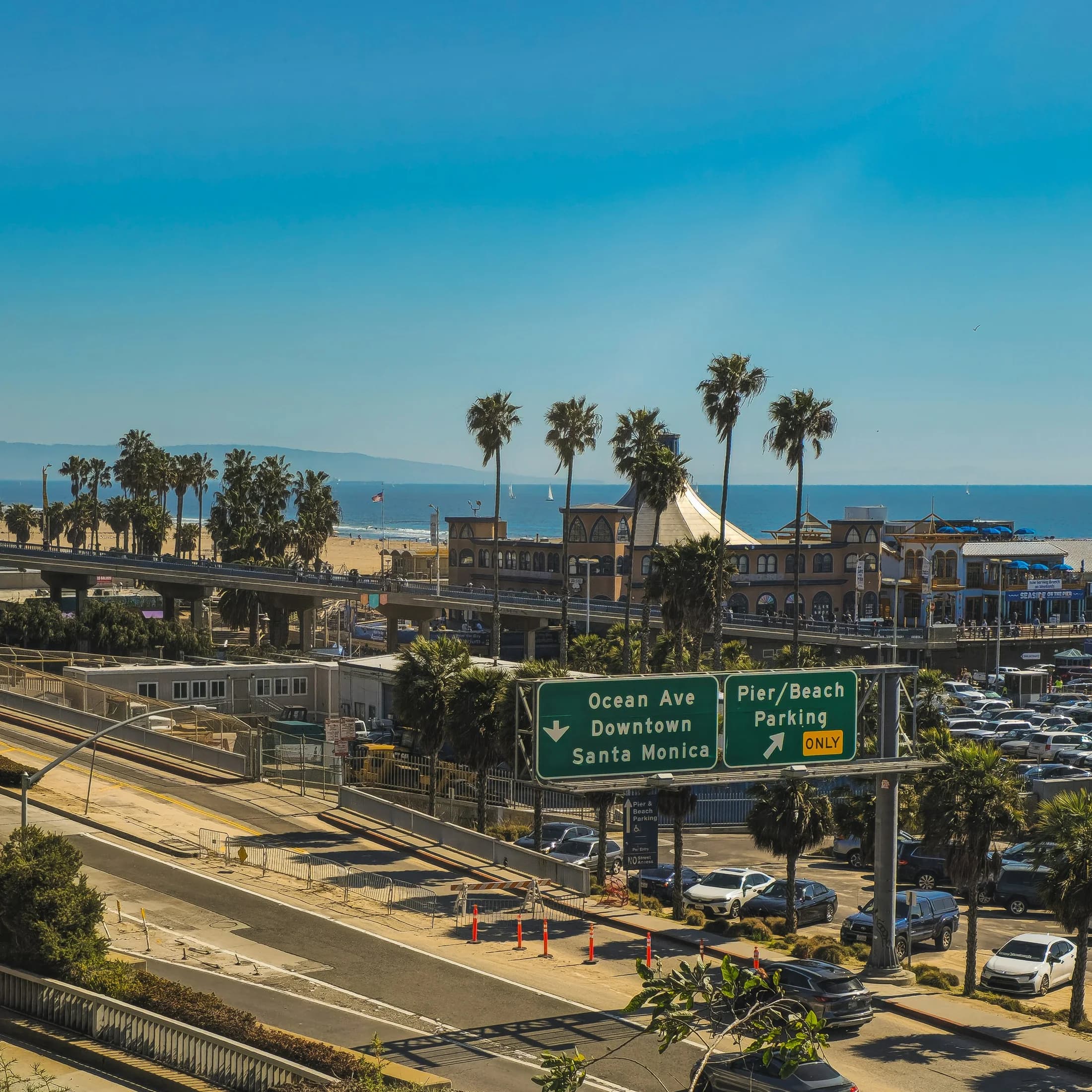 Ocean Avenue, palms, coastal buildings, and Santa Monica Pier viewed from above