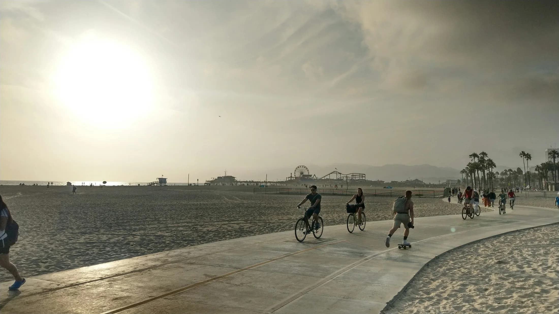 Cyclists and pedestrians sharing the paved path beside Santa Monica Beach