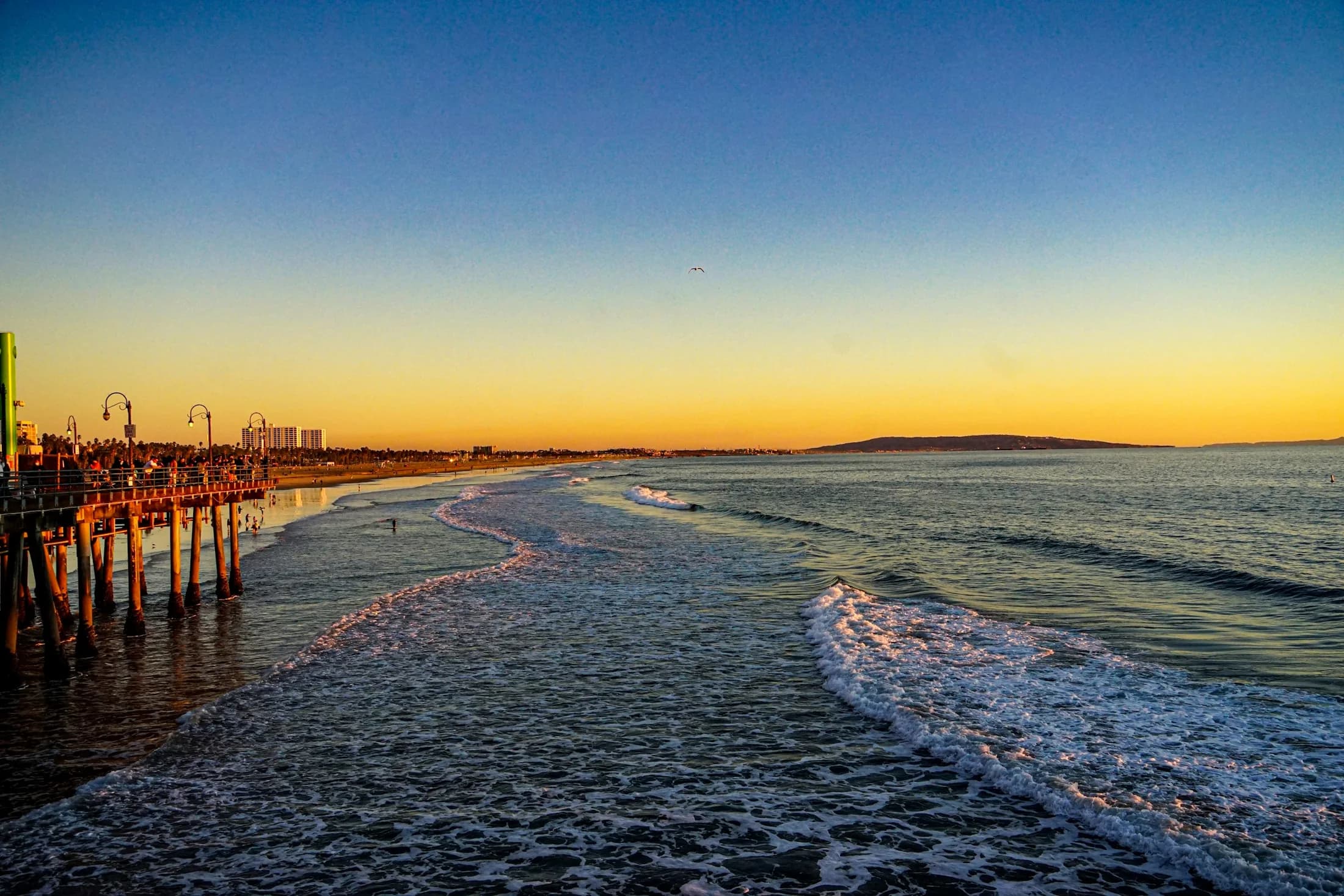 A quiet Santa Monica shoreline with the pier in the distance at sunset