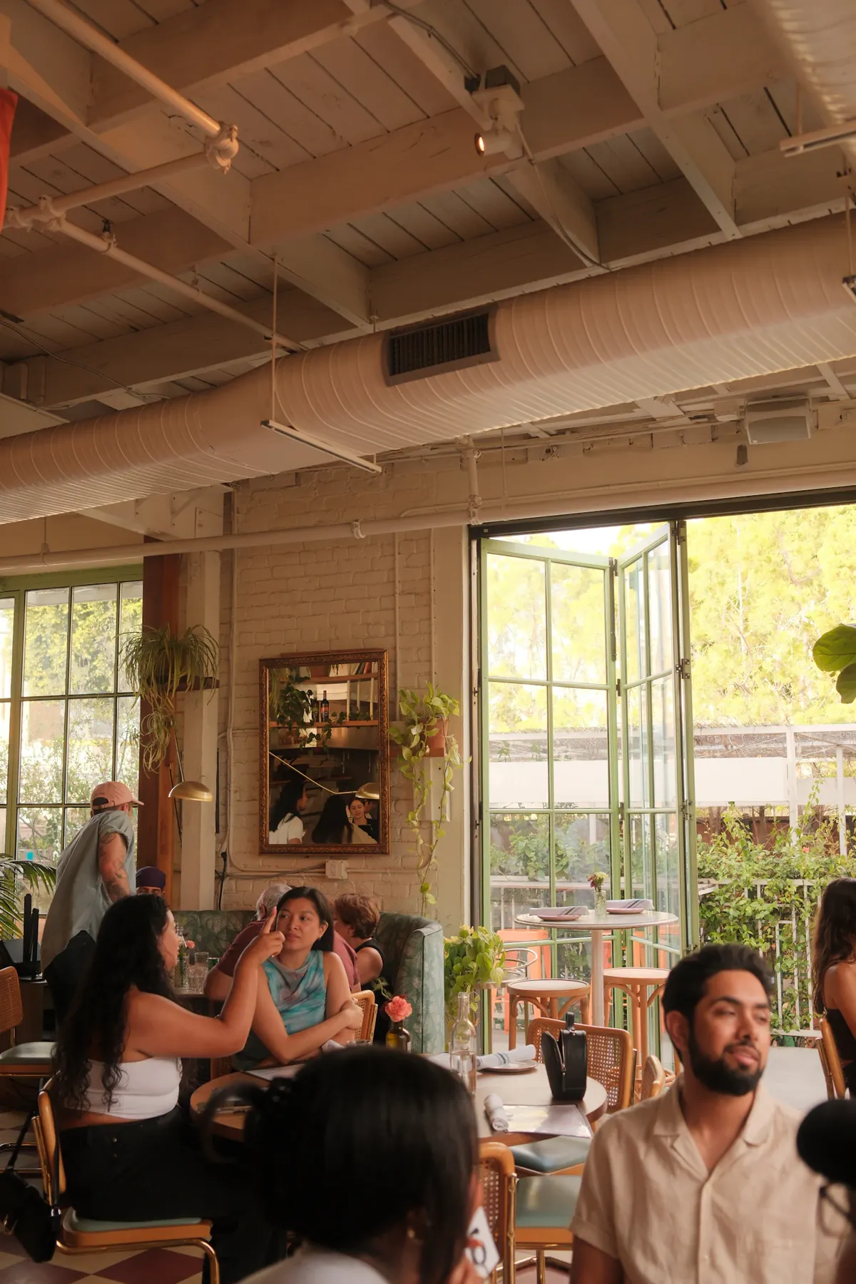 A bright neighborhood cafe filled with people sharing tables