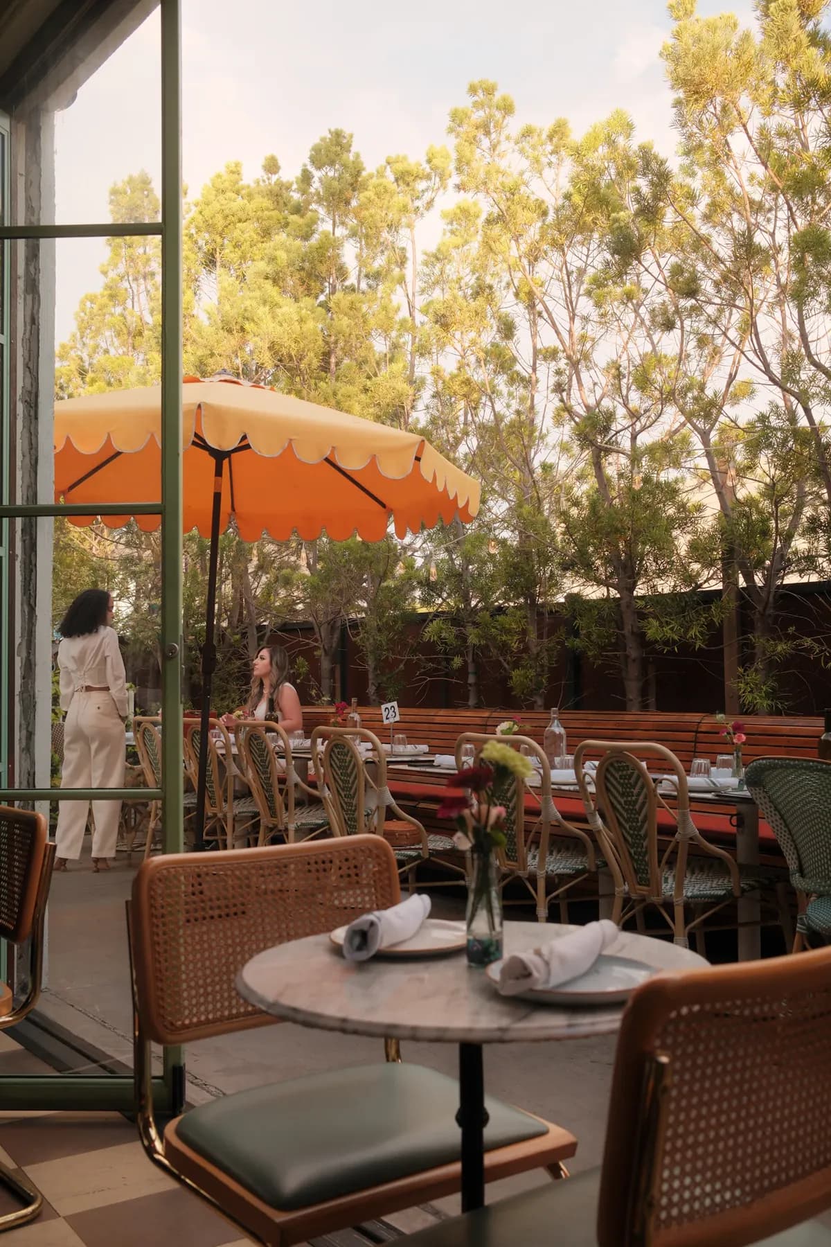 An inviting outdoor restaurant patio set beneath a bright awning