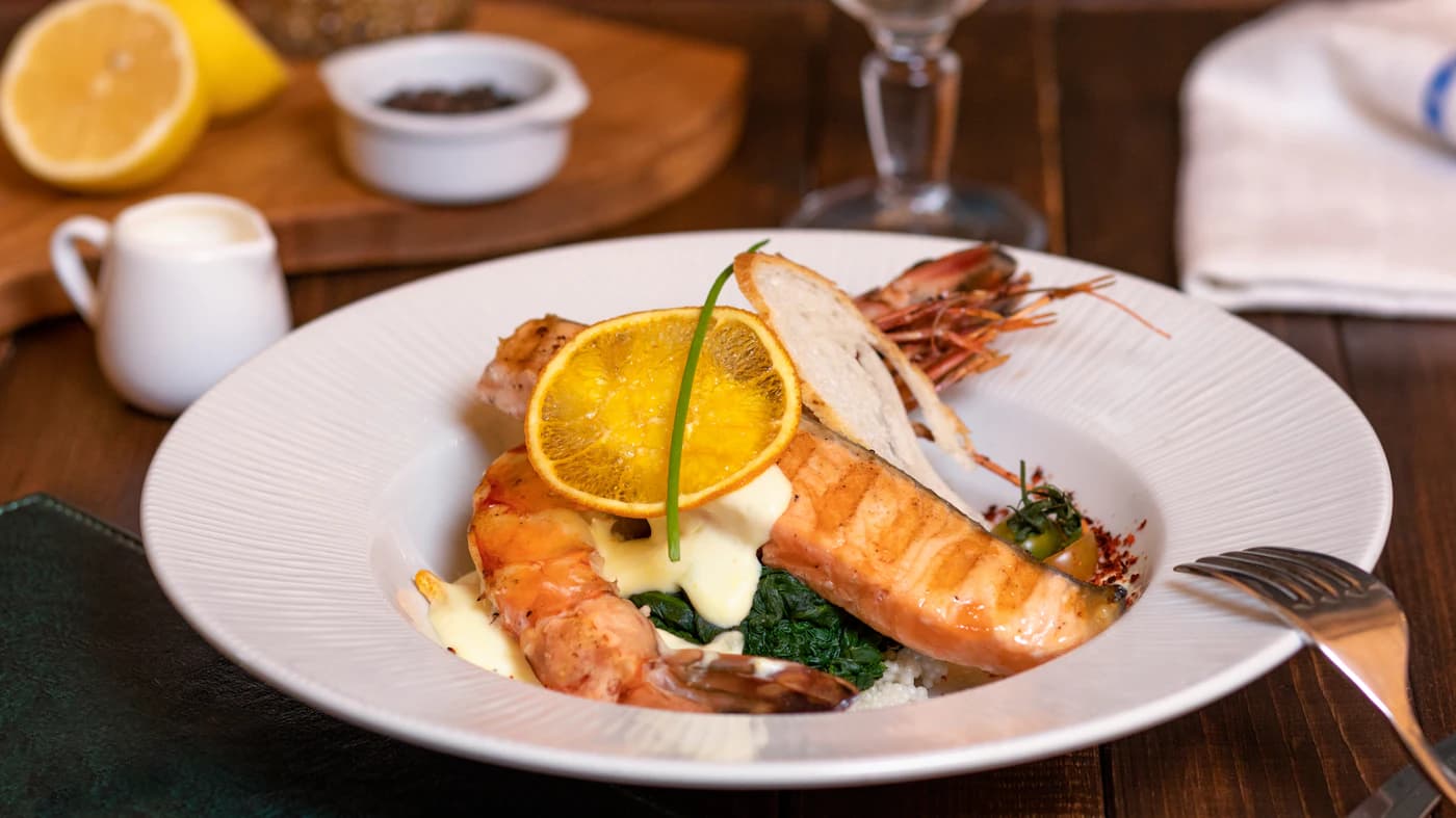 A carefully plated coastal dinner with citrus and fresh seafood