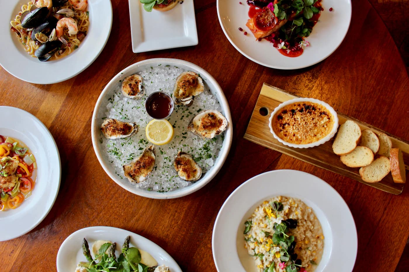 A shared table filled with colorful small plates and fresh dishes