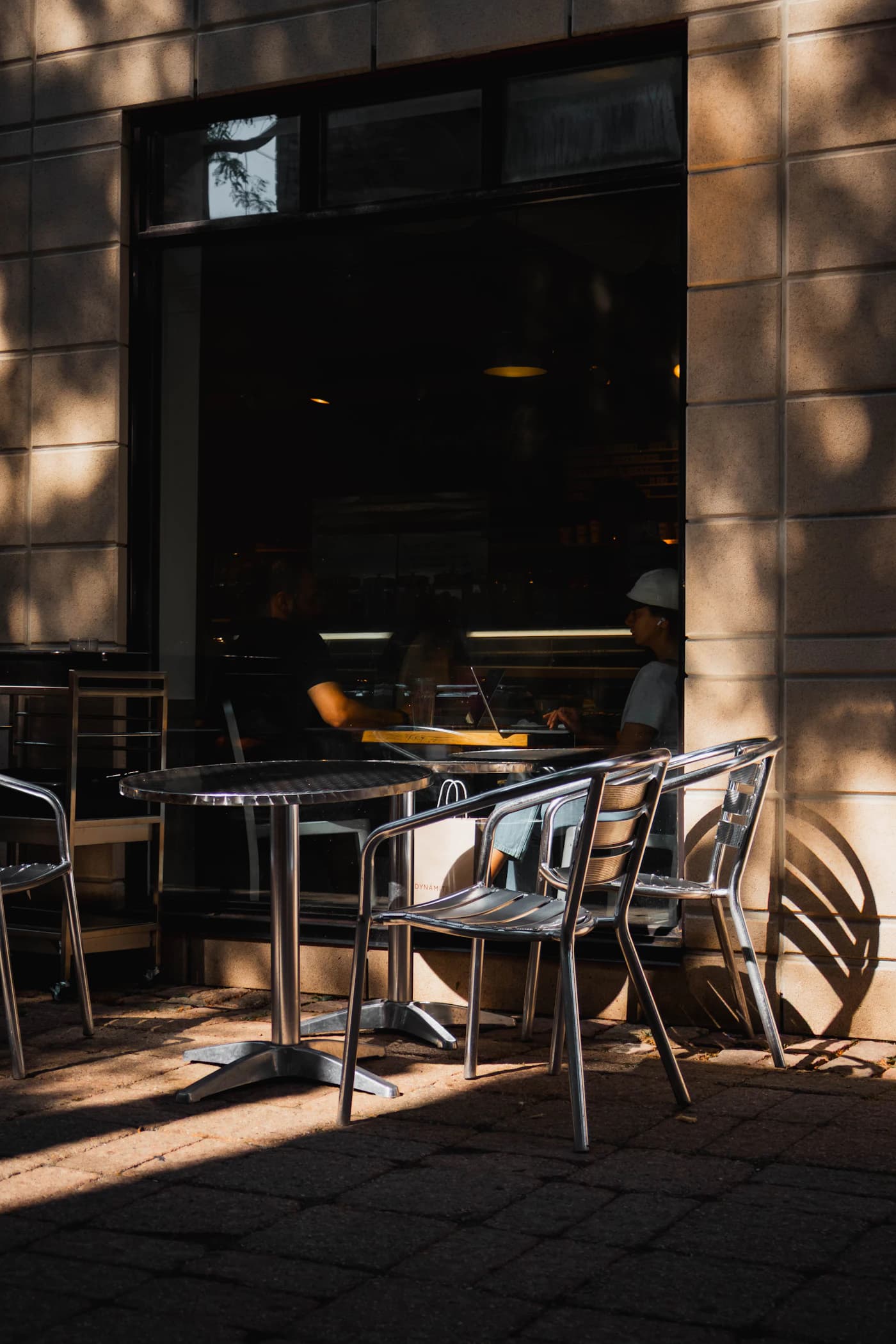 Tables arranged along a shaded neighborhood café