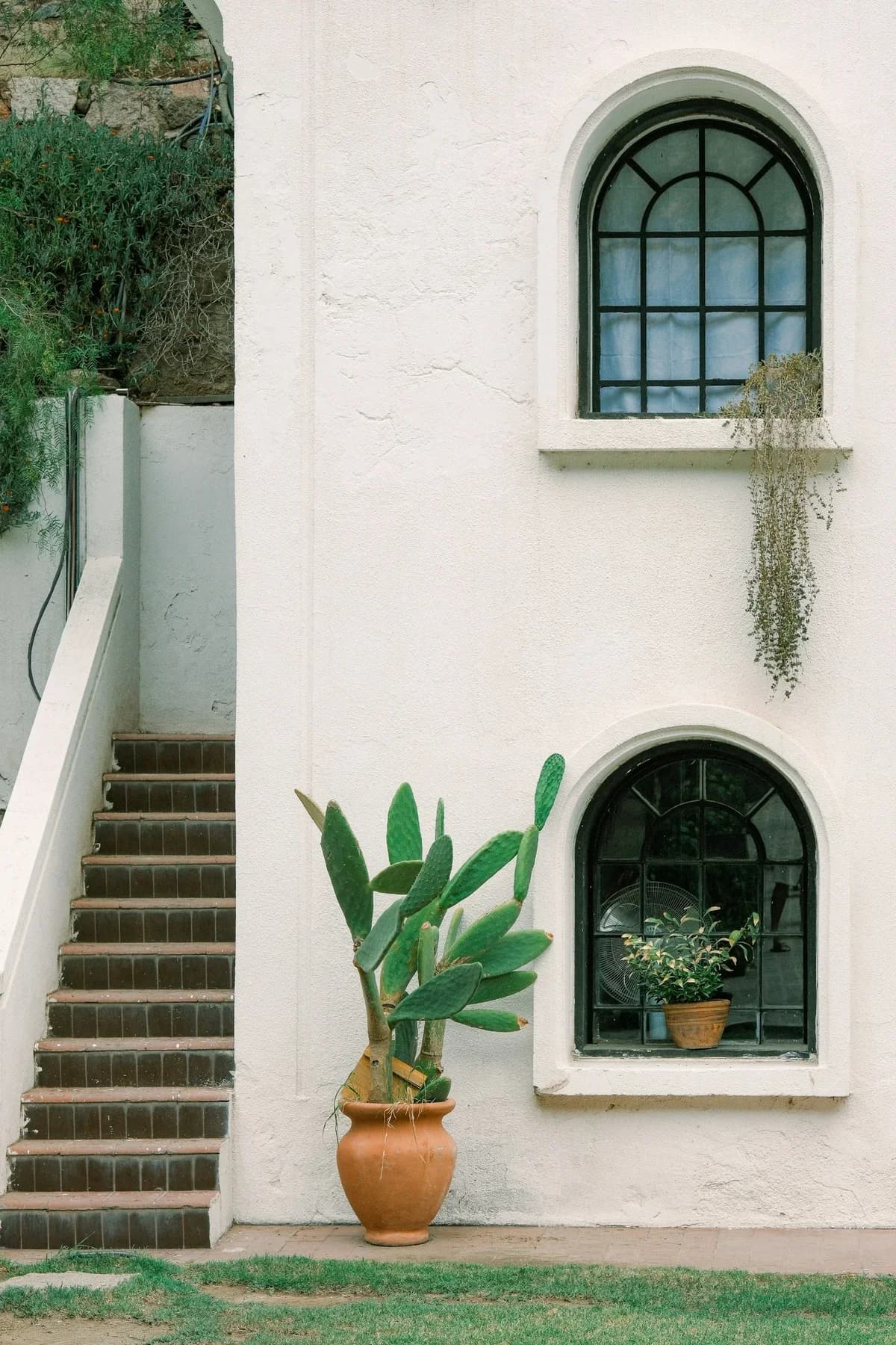 A white stucco residence with deep arched windows