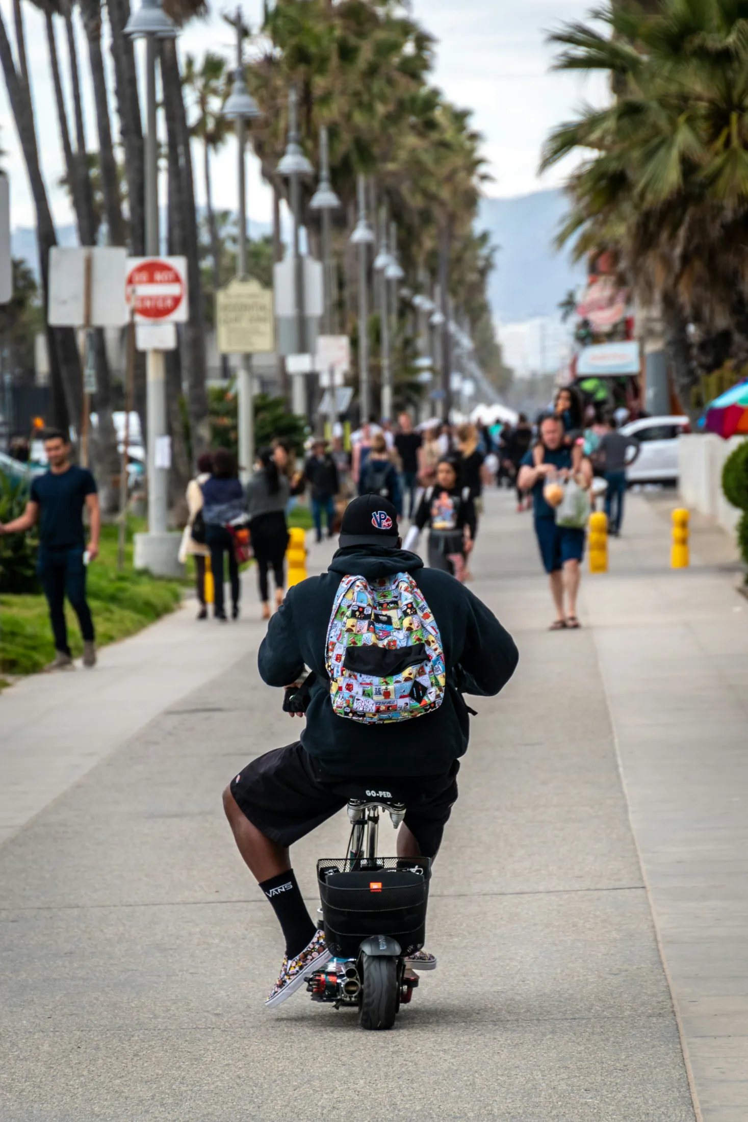 A cyclist moving through the busy pedestrian rhythm of Ocean Front Walk