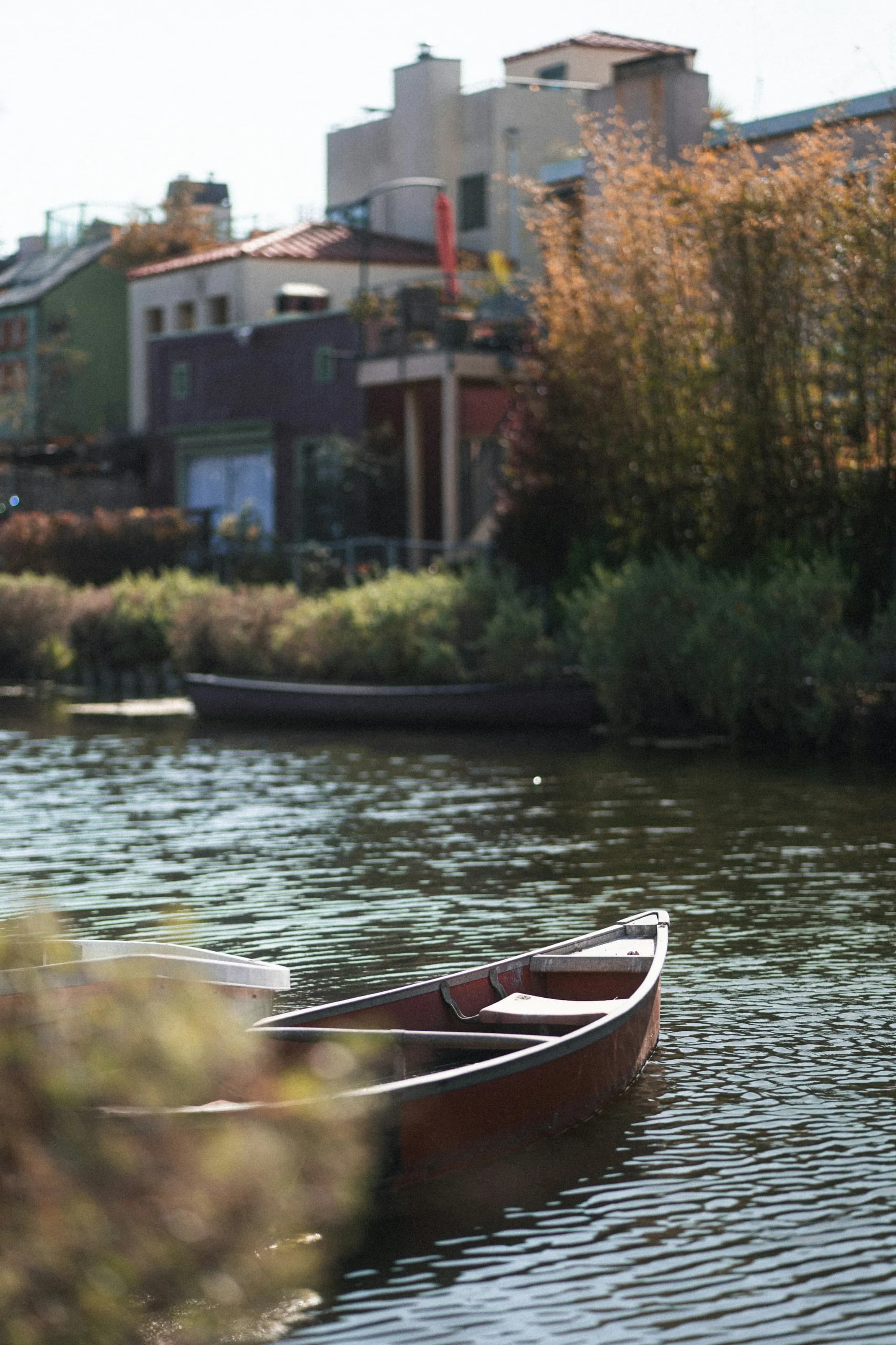 A small boat floating beside closely spaced homes along a Venice canal