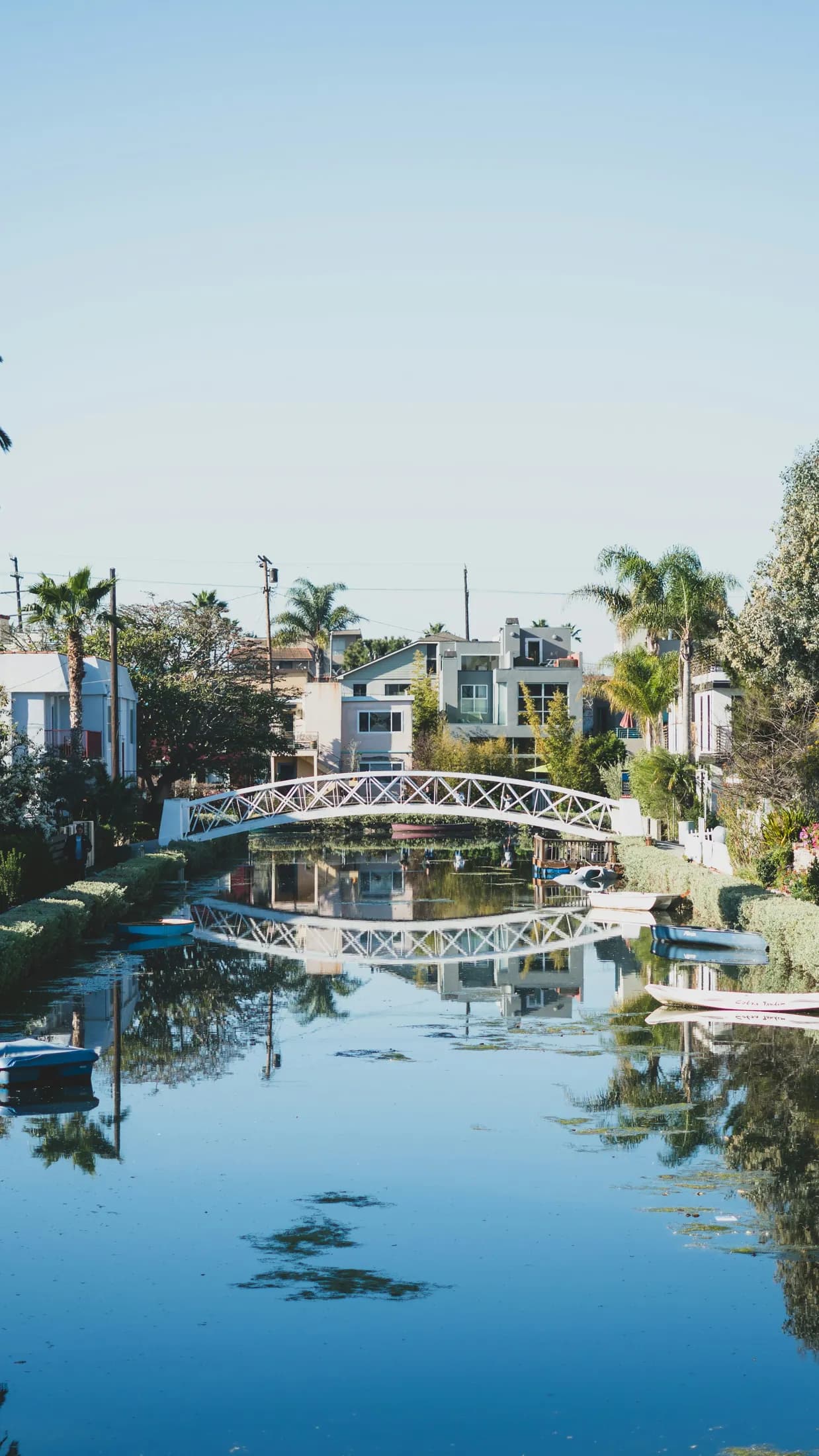 A slender canal view framed by bridges and Venice residences