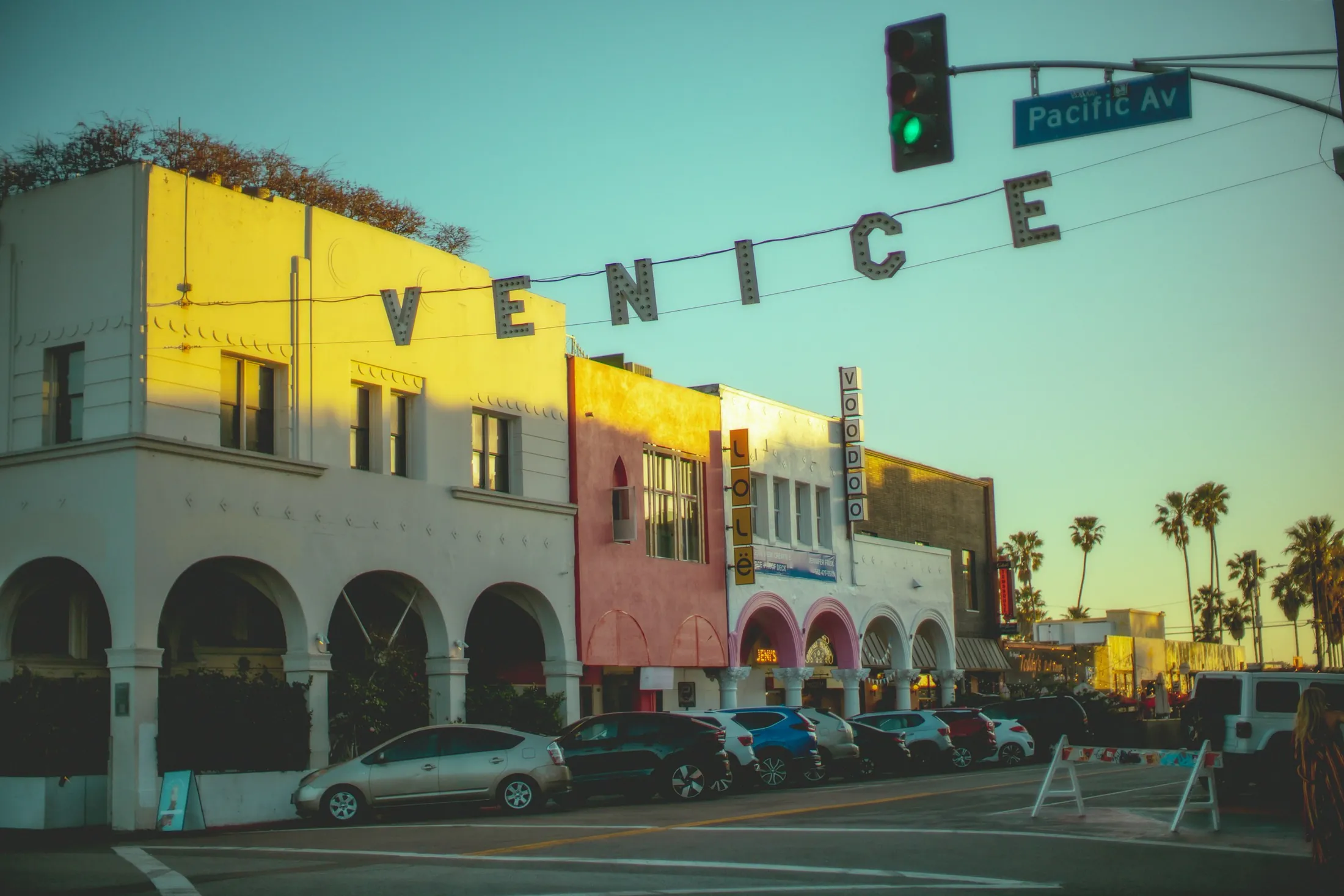 The suspended Venice sign and colorful Windward Avenue buildings at sunset