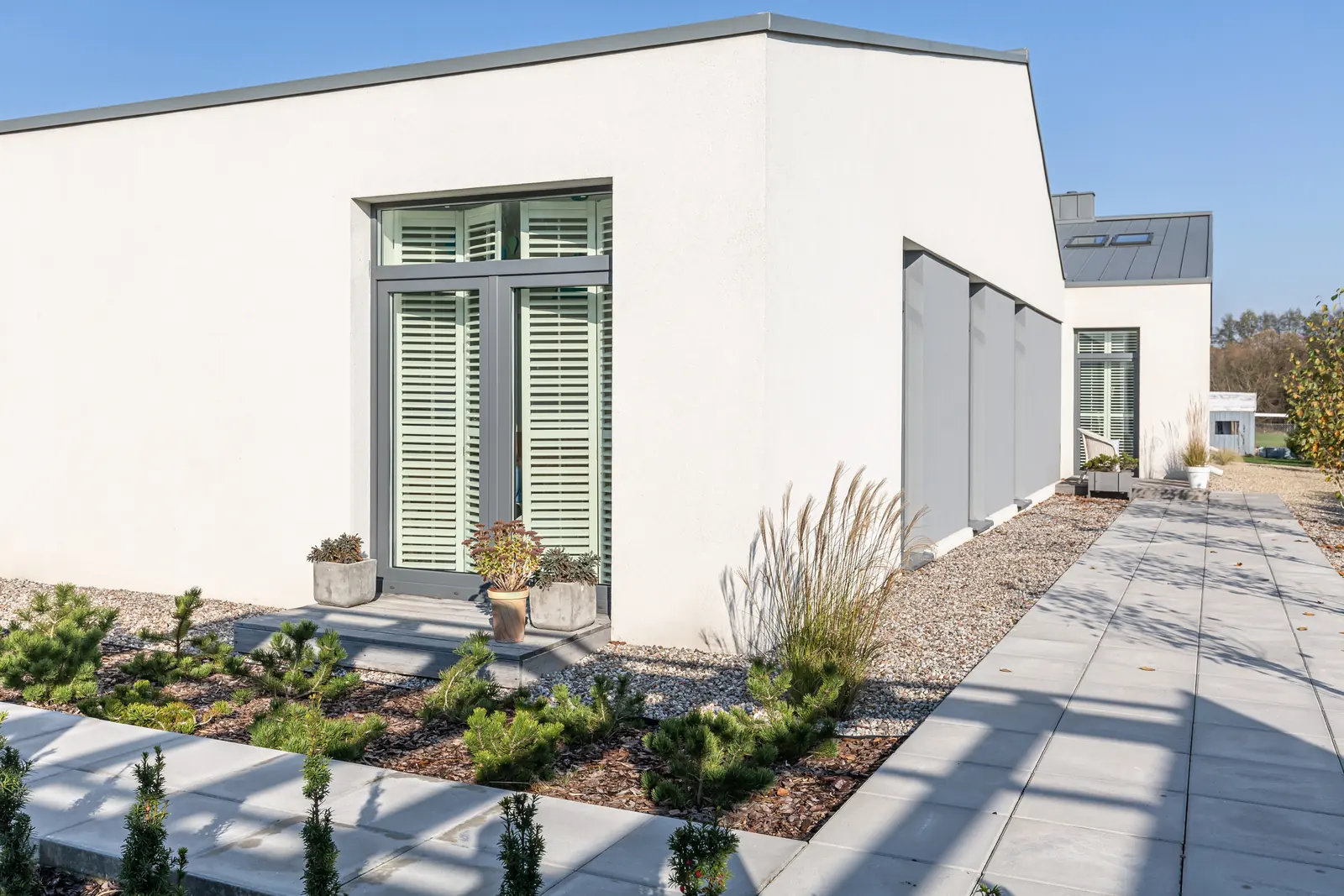A contemporary white home with drought-conscious landscaping