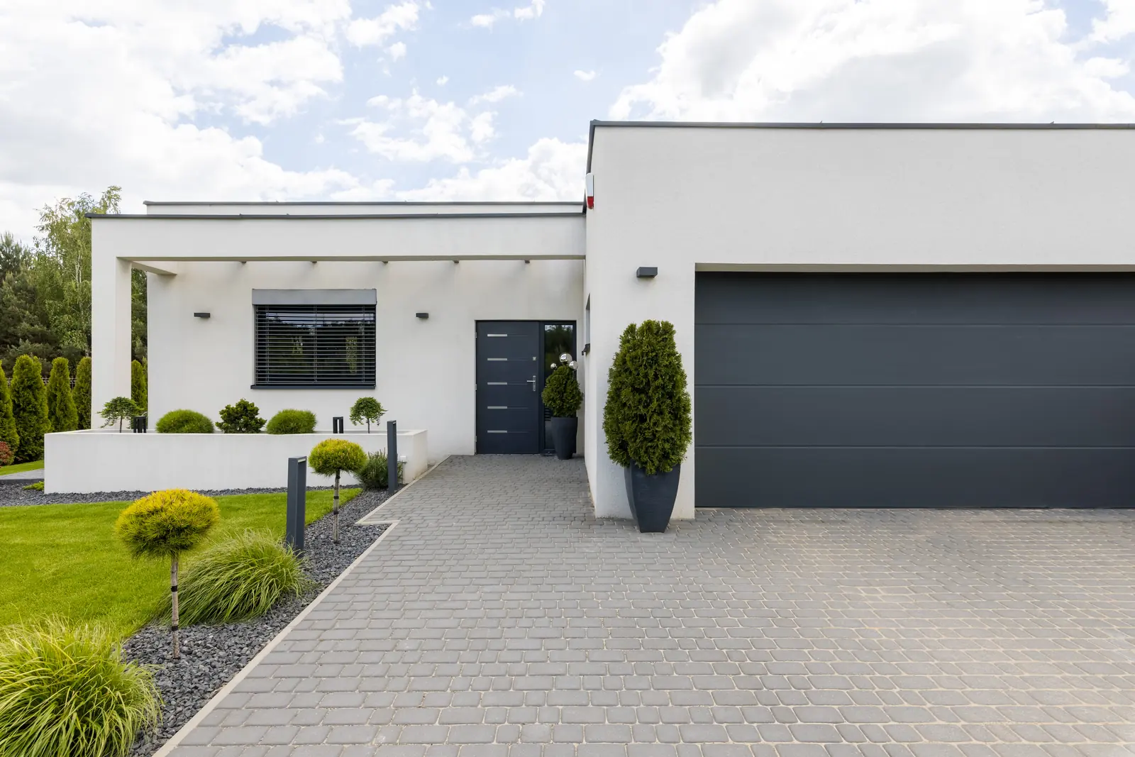 A landscaped contemporary home with a welcoming front drive