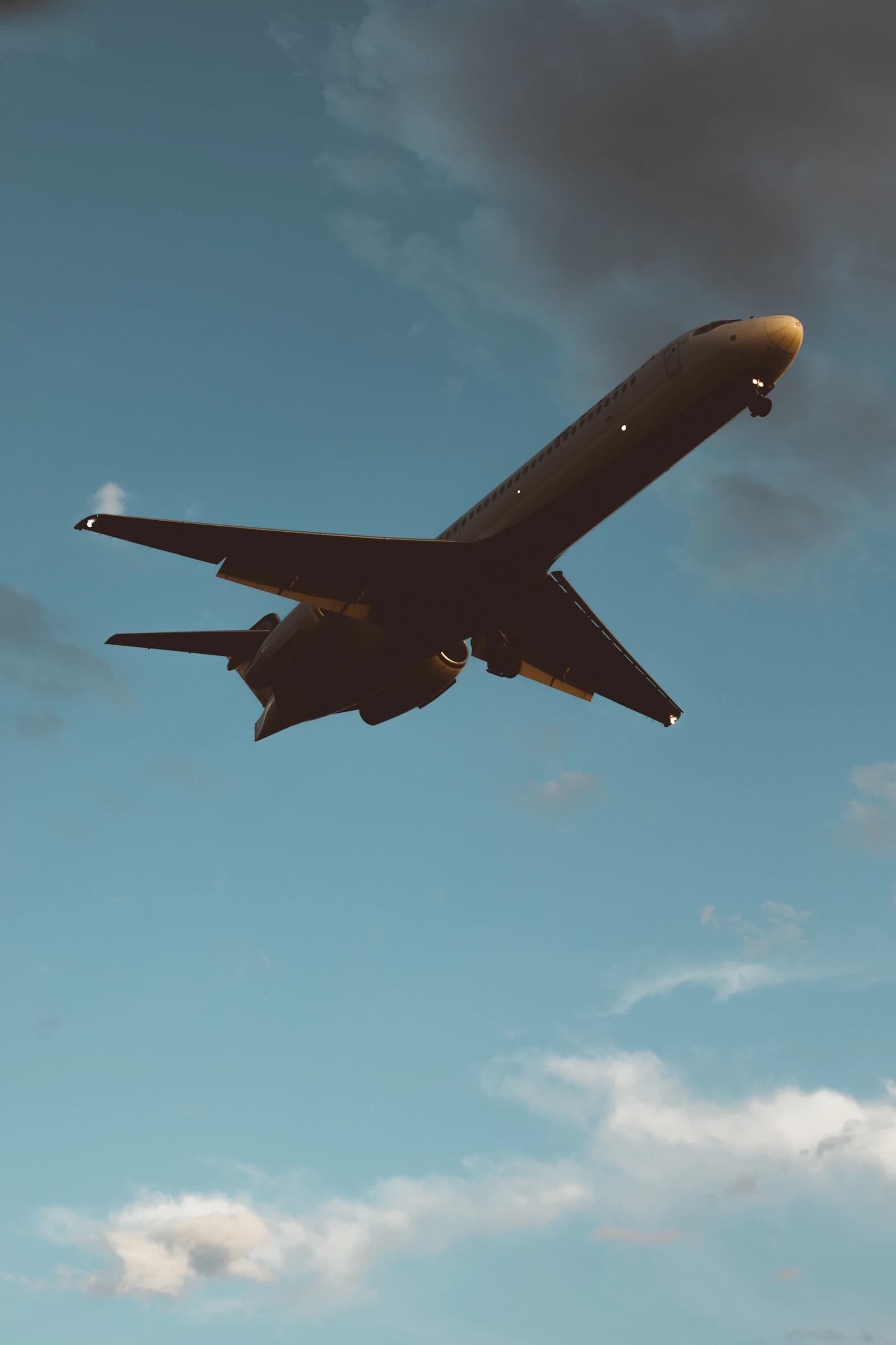 A commercial aircraft approaching LAX through broken clouds