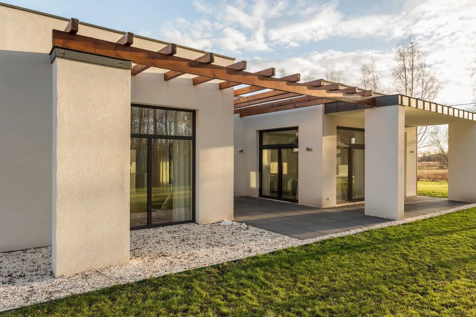A warm stucco home with a shaded outdoor pergola